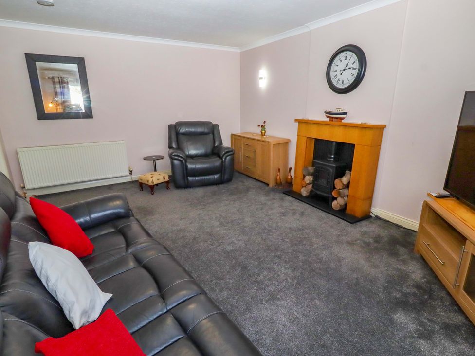 A living room with a sofa and armchair at Willow cottage Seahouses