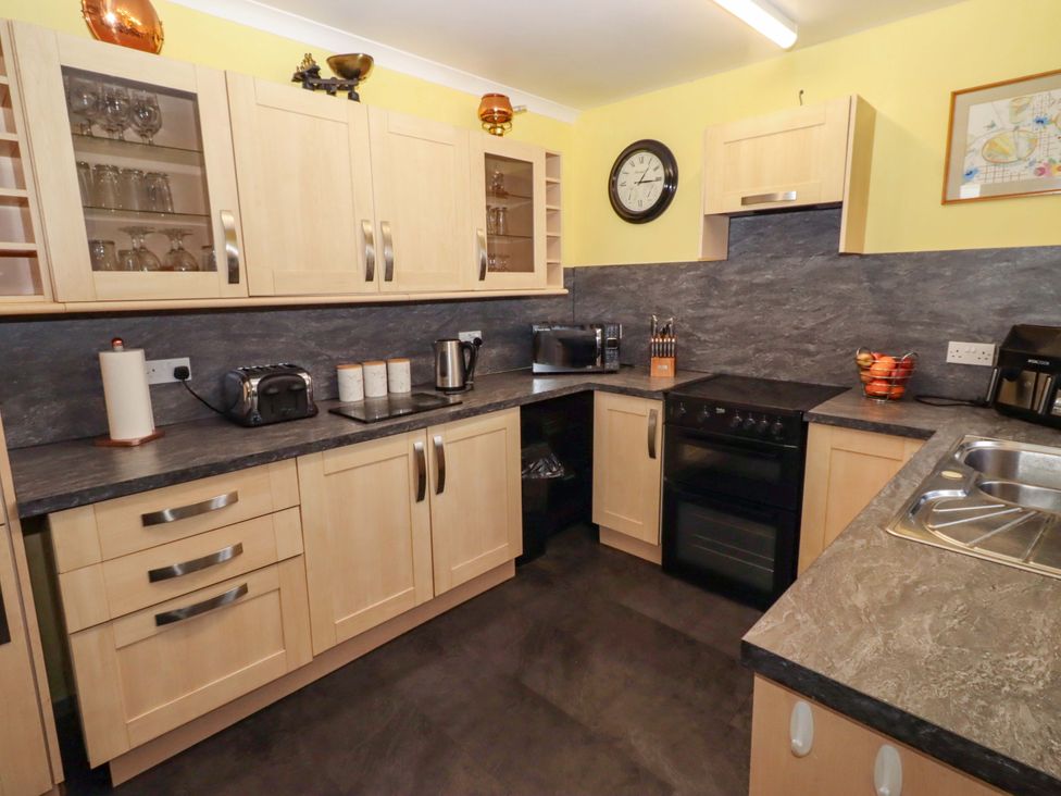 A kitchen with appliances and storage at Willow cottage Seahouses