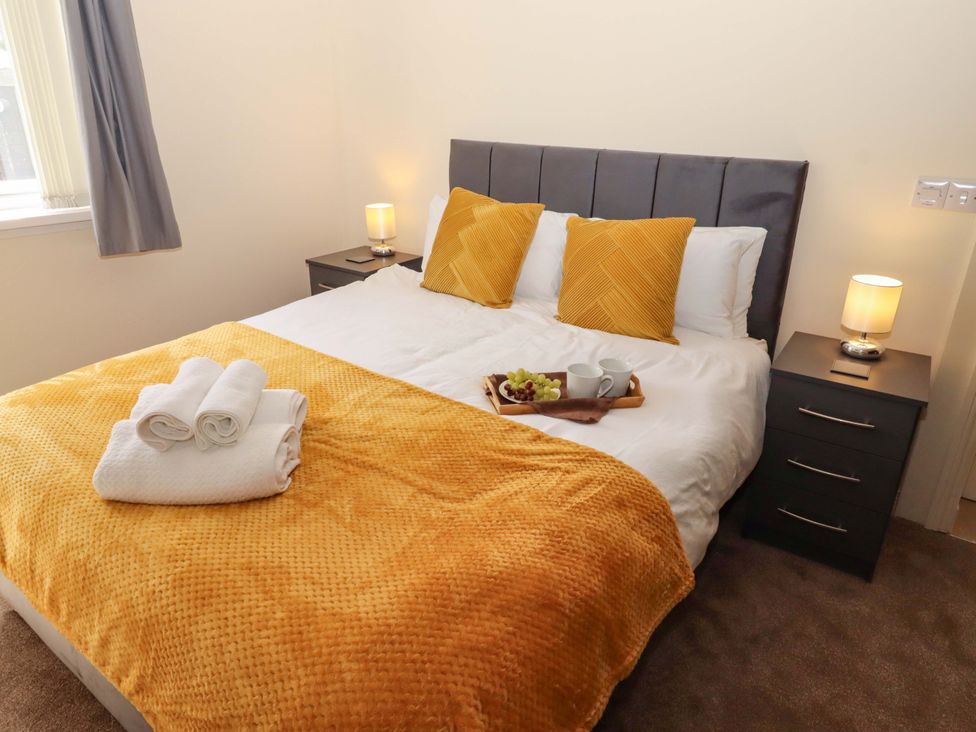 A bedroom with a bed and bedside table at Willow cottage Seahouses