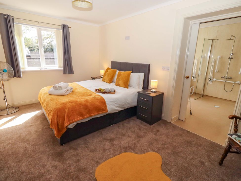 A bedroom with a bed and ensuite bathroom at Willow cottage, Seahouses