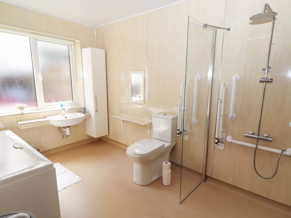 A bathroom with a bathtub, shower, sink, and toilet at Willow cottage in Seahouses
