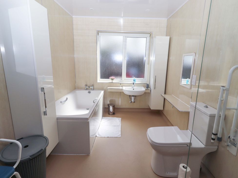 A bathroom with a bathtub, toilet, and sink at Willow cottage in Seahouses