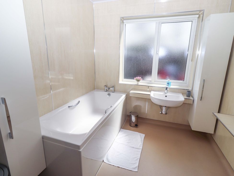 A bathroom with a bathtub and sink at Willow cottage in Seahouses