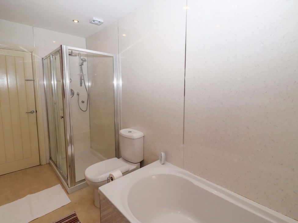 A bathroom with a shower and bathtub at Willow cottage Seahouses