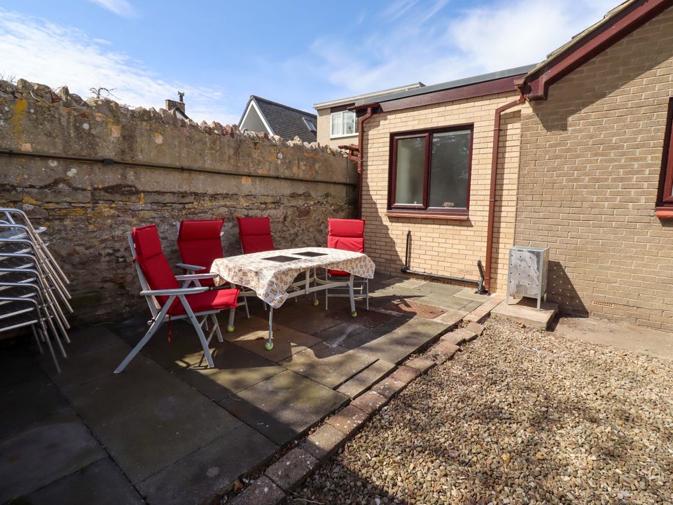 An outdoor area with a table and chairs at Willow cottage in Seahouses