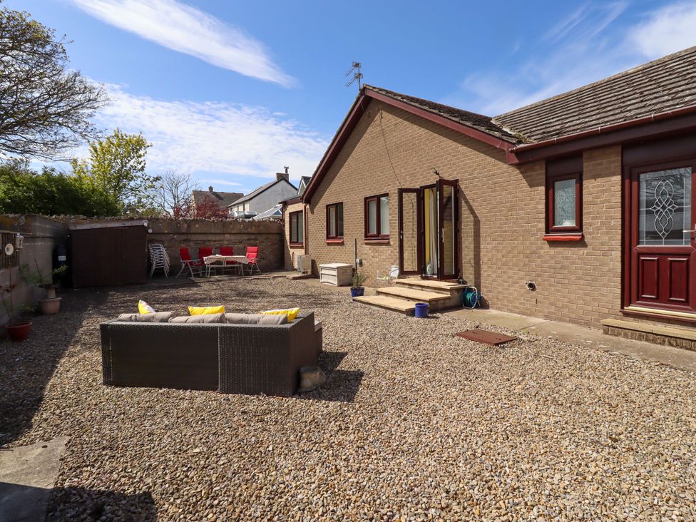 A patio area with a gravel surface and furniture at Willow cottage Seahouses