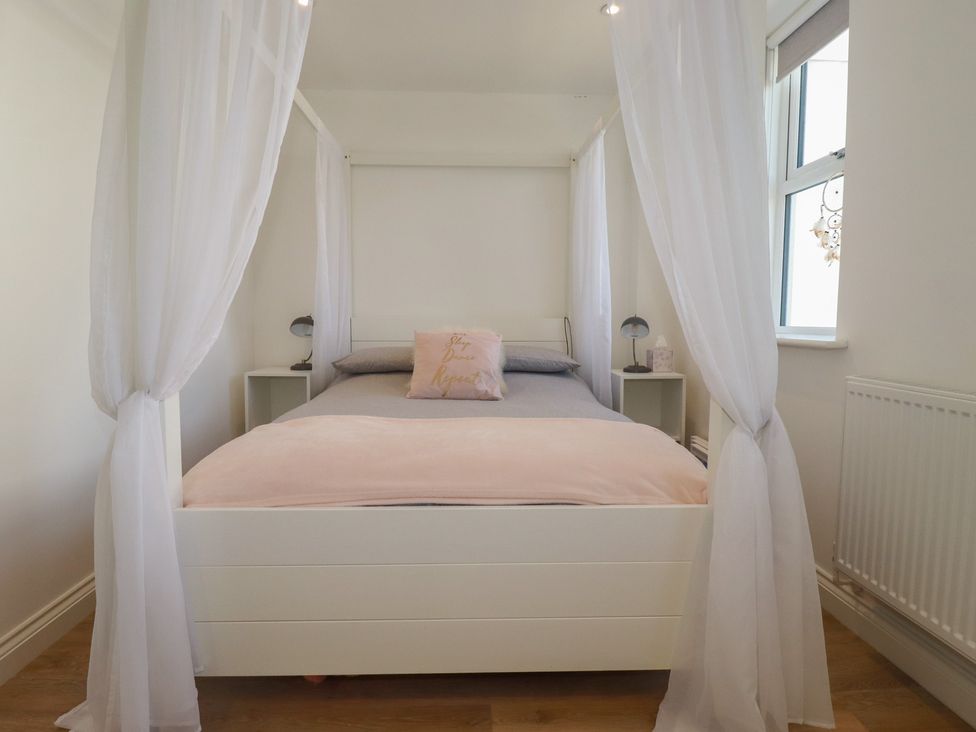 A bedroom with a bed and lamp at Cwtch Treth in Newquay