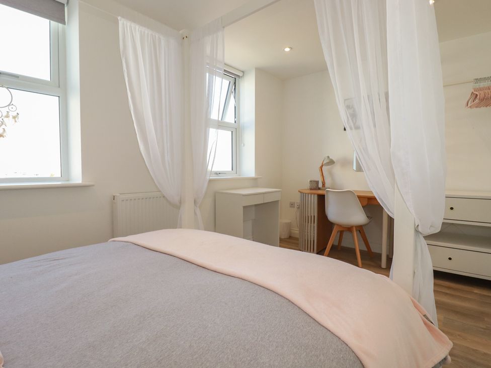 A bedroom with a bed and desk at Cwtch Treth in Newquay