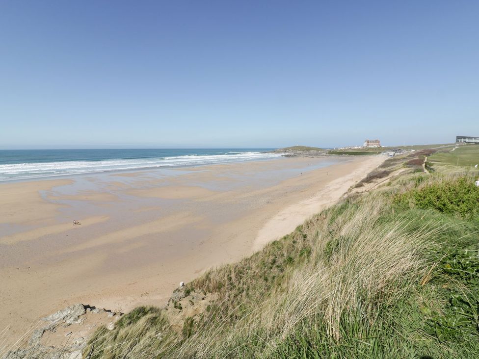 A beach with sand and ocean waves at Cwtch Treth in Newquay
