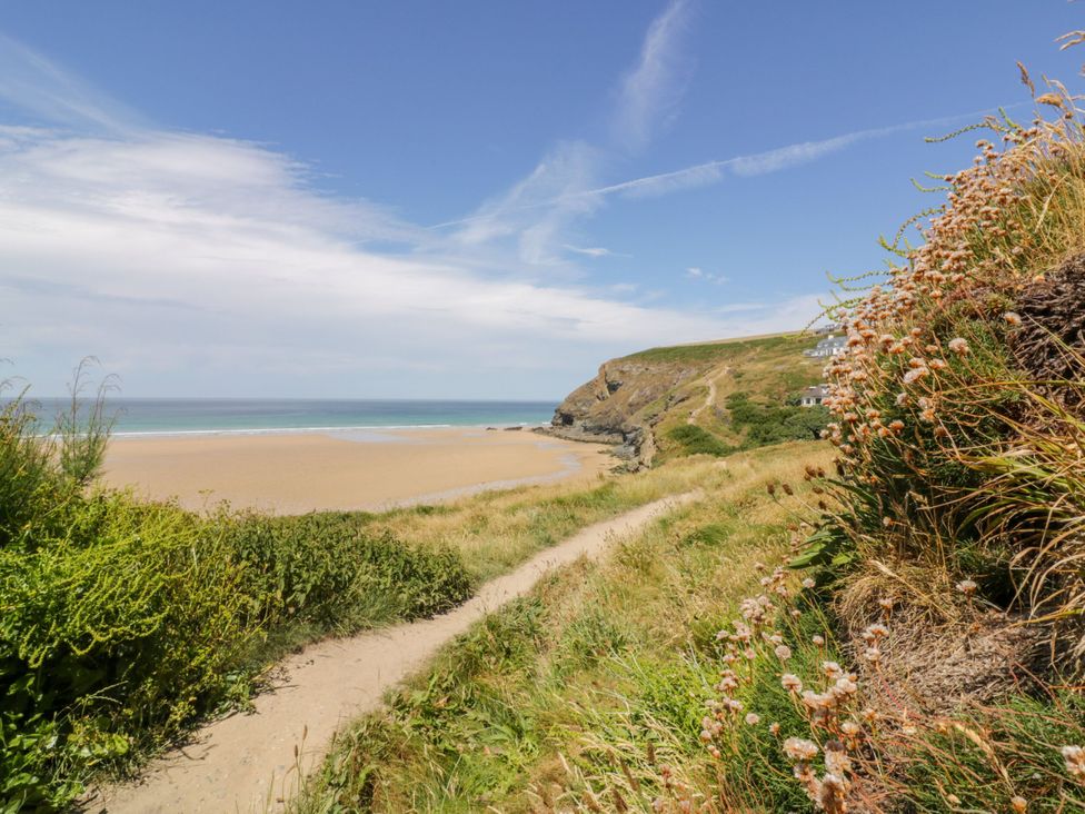 A beach with a pathway leading to the ocean at Cwtch Treth in Newquay
