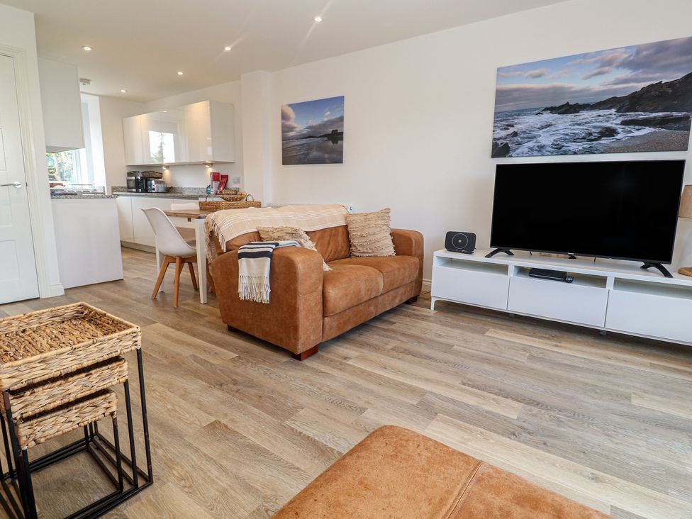 A living room with a sofa and television at Cwtch Treth in Newquay