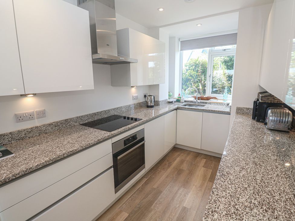 A kitchen with appliances and countertops at Cwtch Treth in Newquay