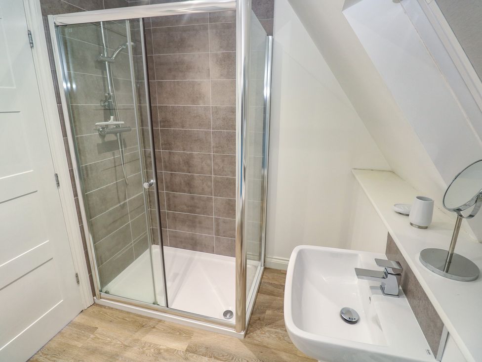 A bathroom with a shower and sink at Cwtch Treth in Newquay