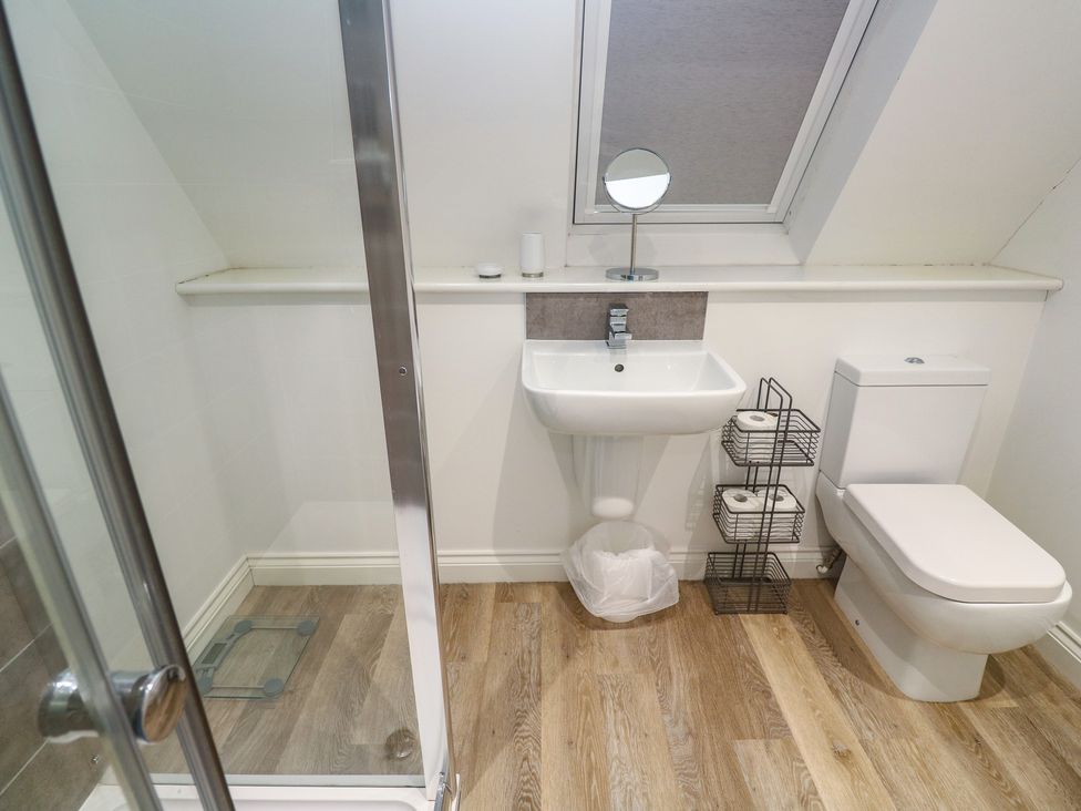 A bathroom with a shower, sink, and toilet at Cwtch Treth in Newquay