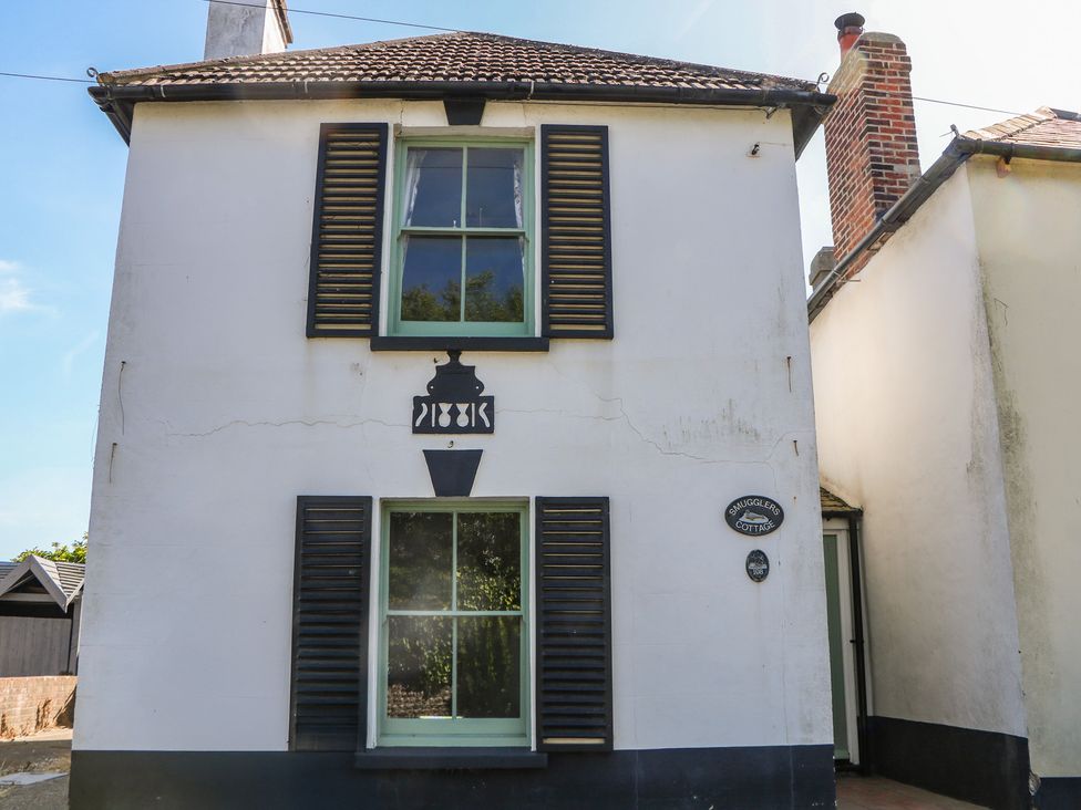 A cottage with windows, door and sign at Smugglers Cottage in Selsey