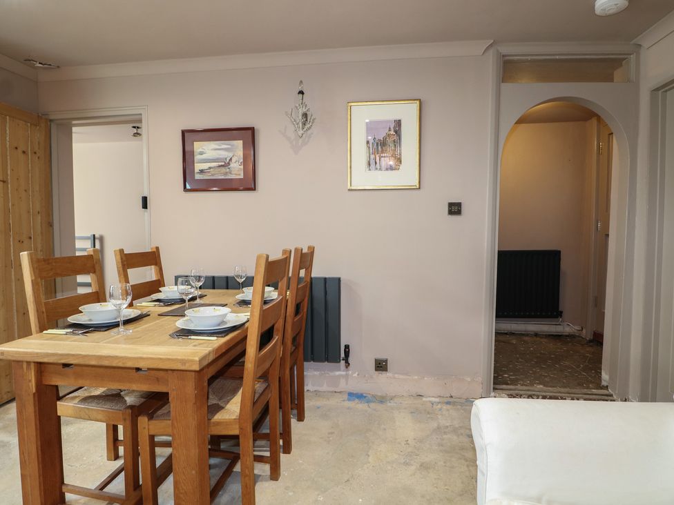 A dining room with a table and chairs at Smugglers Cottage in Selsey