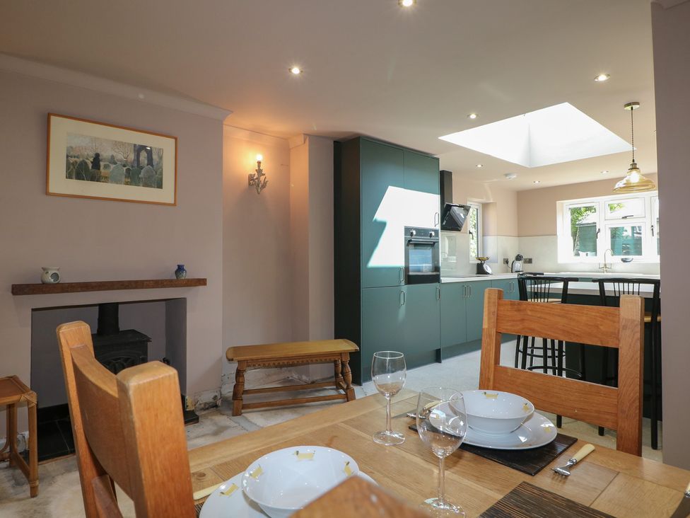 A kitchen with dining table and chairs at Smugglers Cottage in Selsey