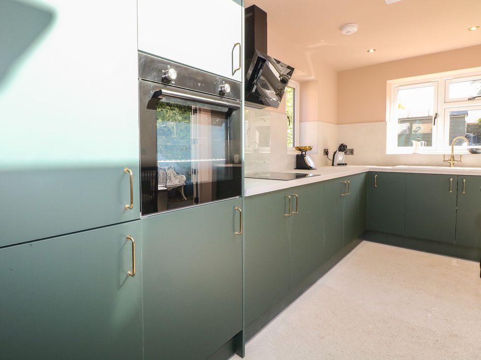 A kitchen featuring cabinets and appliances at Smugglers Cottage in Selsey