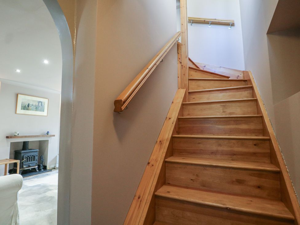 A staircase leading up with a handrail at Smugglers Cottage in Selsey