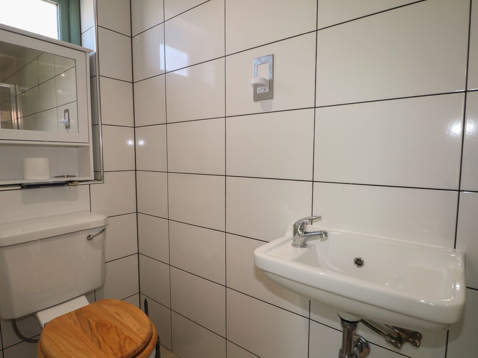 A bathroom with a toilet and sink at Smugglers Cottage in Selsey