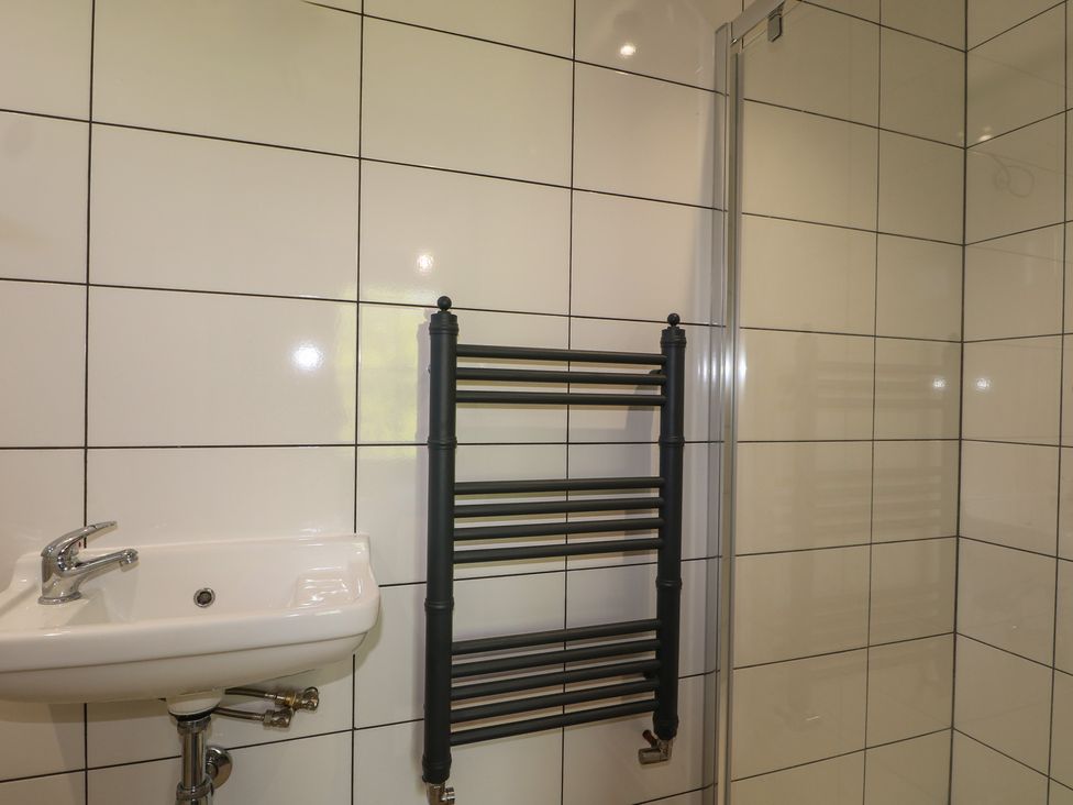 A bathroom with a sink and towel radiator at Smugglers Cottage in Selsey