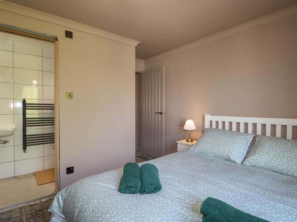 A bedroom with a bed and a towel radiator at Smugglers Cottage in Selsey