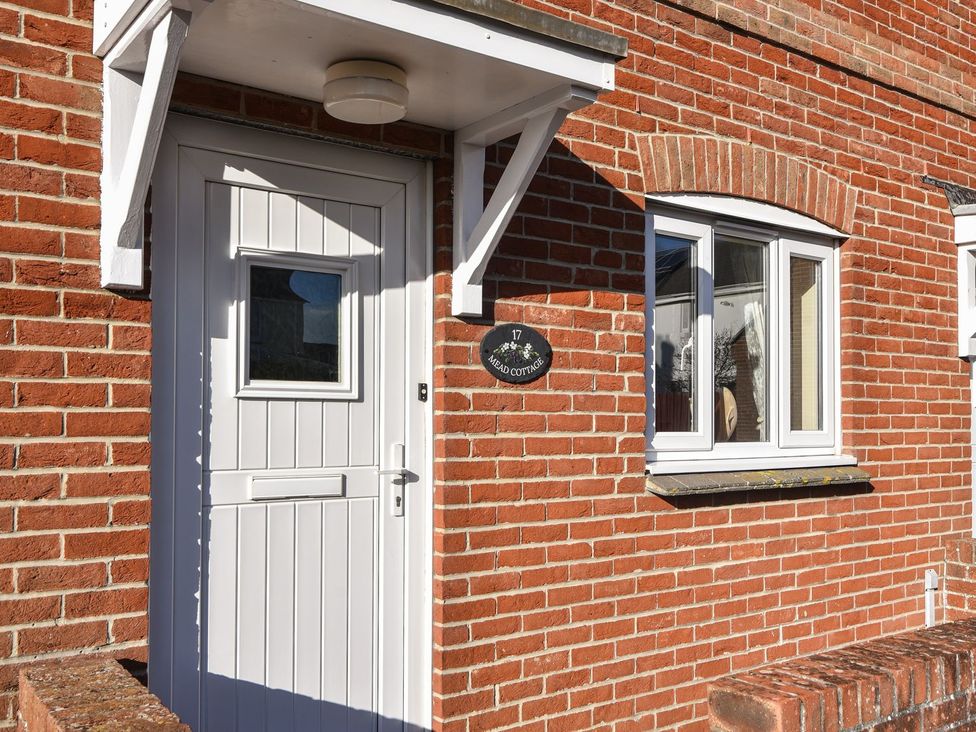 An entrance door and a window of a cottage at Mead Cottage in Bridport