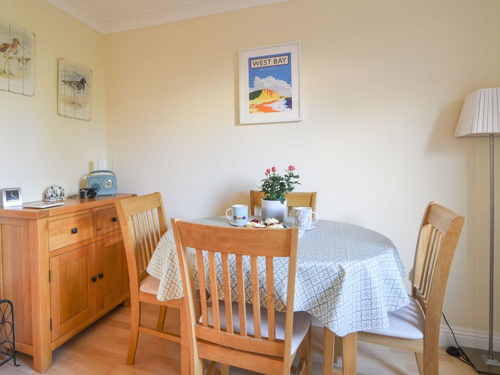 A dining room with a table and chairs at Mead Cottage in Bridport