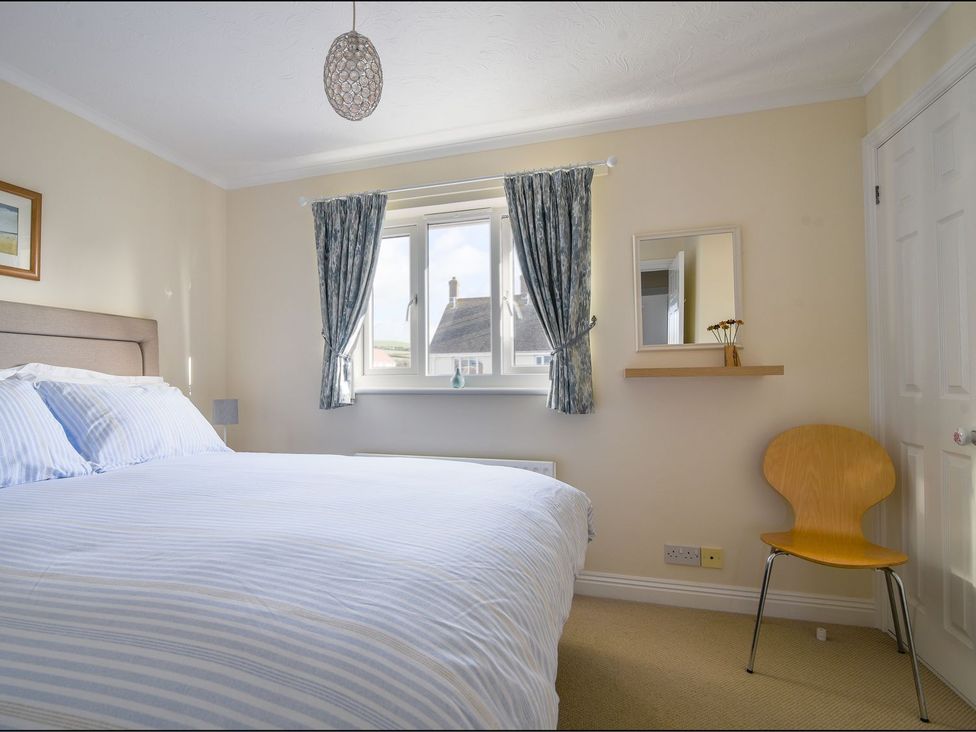 A bedroom with a bed and window at Mead Cottage Bridport