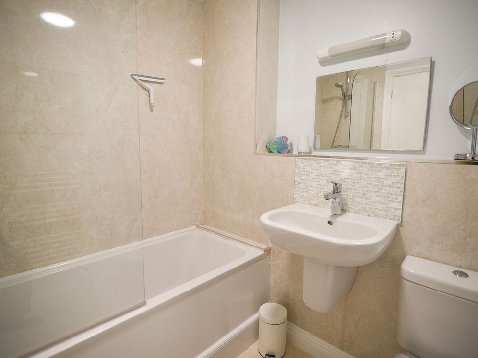A bathroom with a shower and bathtub at Mead Cottage in Bridport