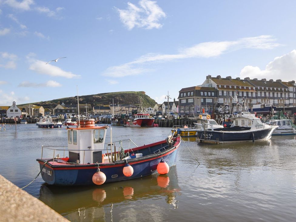 A harbor with boats and buildings at Mead Cottage in Bridport