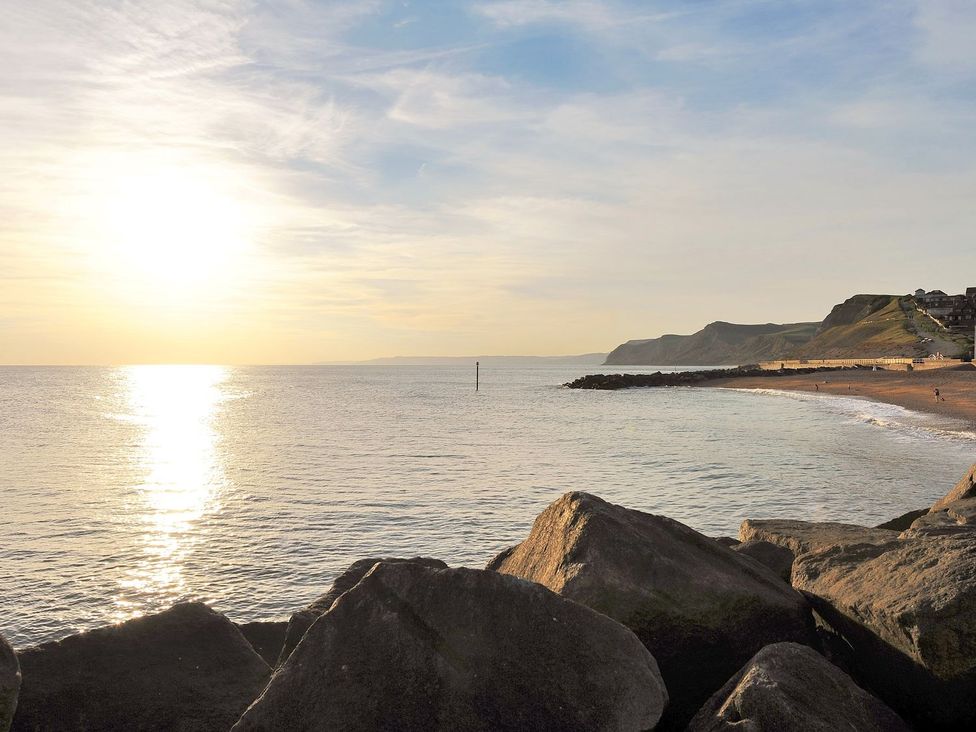 A beach view with rocks and sunset at Mead Cottage in Bridport
