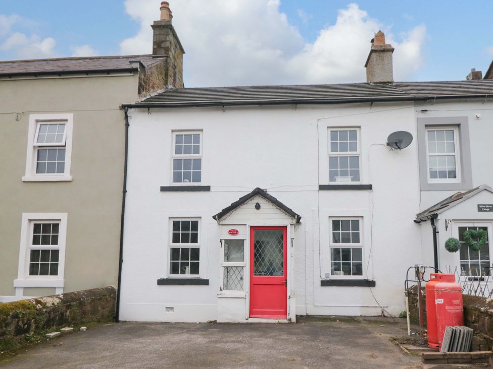 A house with a red door and windows at The Old Post Office in Whitehaven