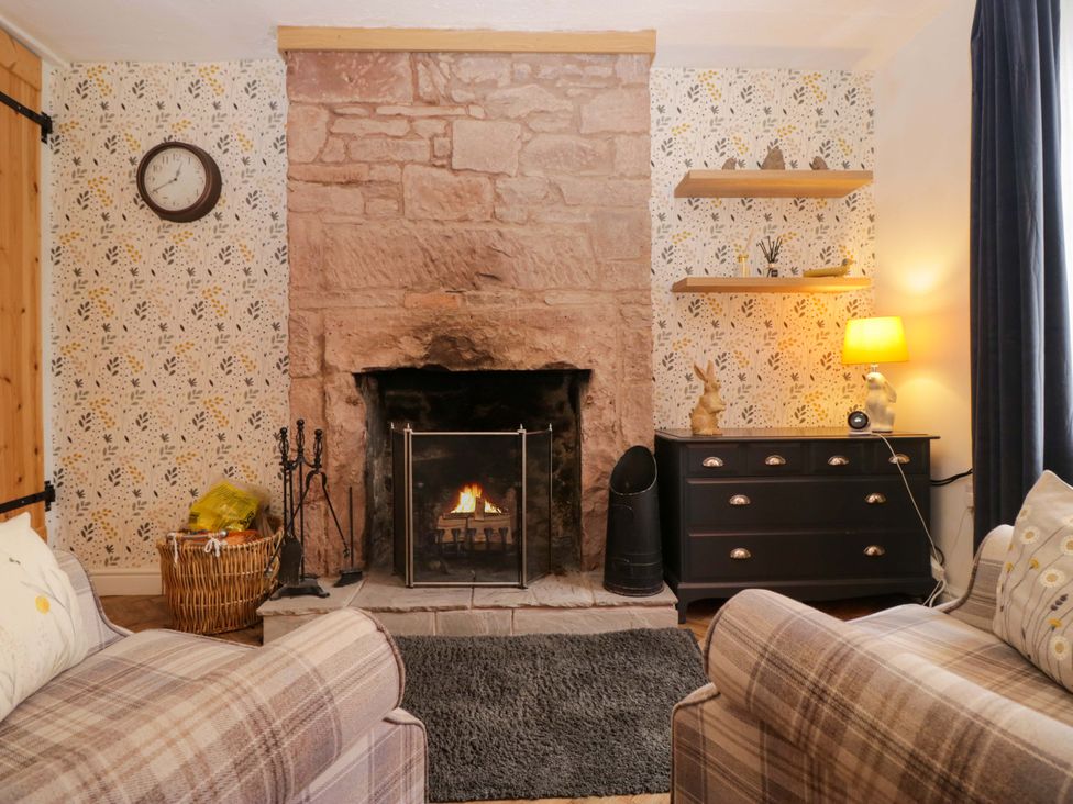 A living room with a fireplace and furniture at The Old Post Office in Whitehaven