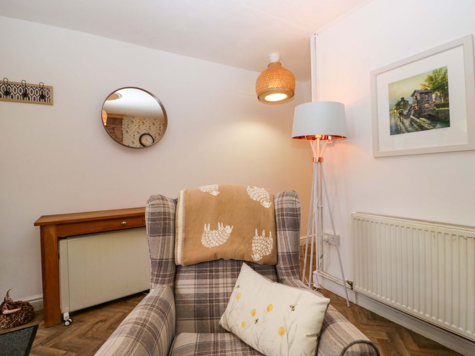 A living room with an armchair and a lamp at The Old Post Office in Whitehaven