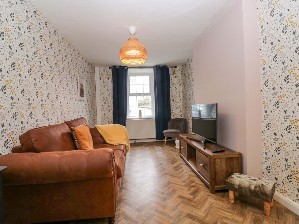 A living room with a sofa and television at The Old Post Office in Whitehaven