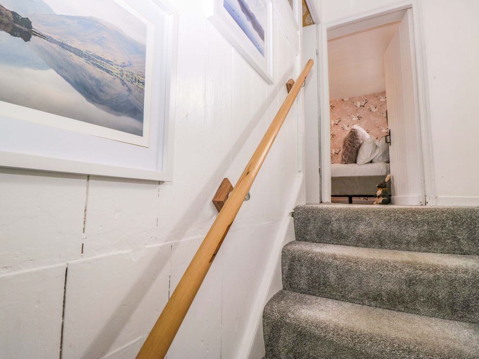 Stairs with a handrail and pictures on the wall at The Old Post Office in Whitehaven