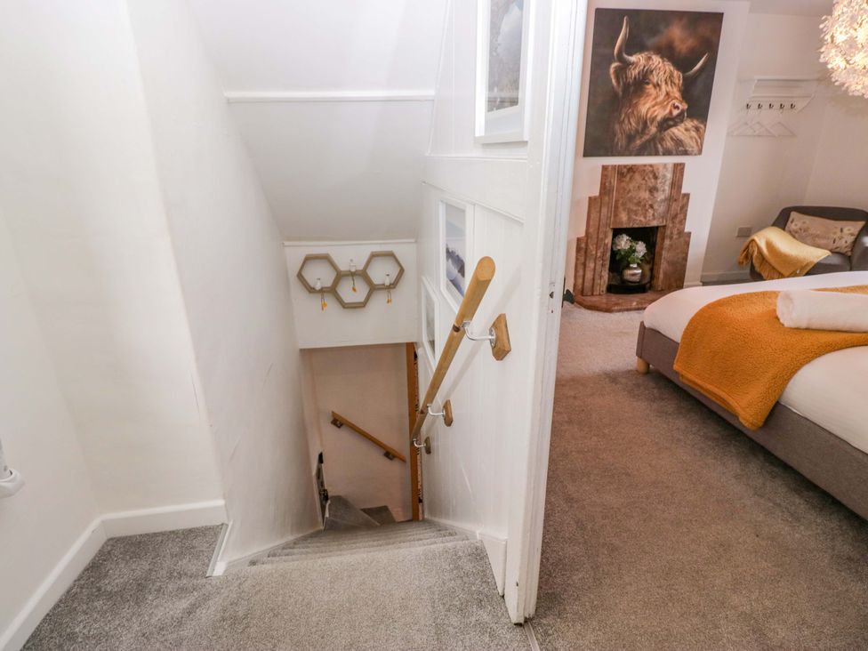 A staircase leading to a bedroom with a sofa and fireplace at The Old Post Office in Whitehaven