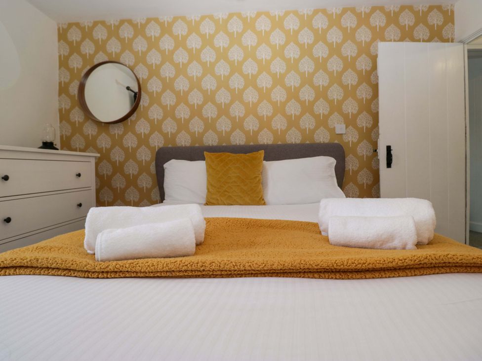 A bedroom with a bed and towels at The Old Post Office in Whitehaven