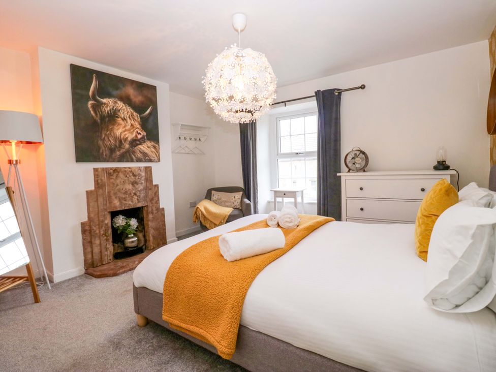 A bedroom with a bed and decorative items at The Old Post Office in Whitehaven