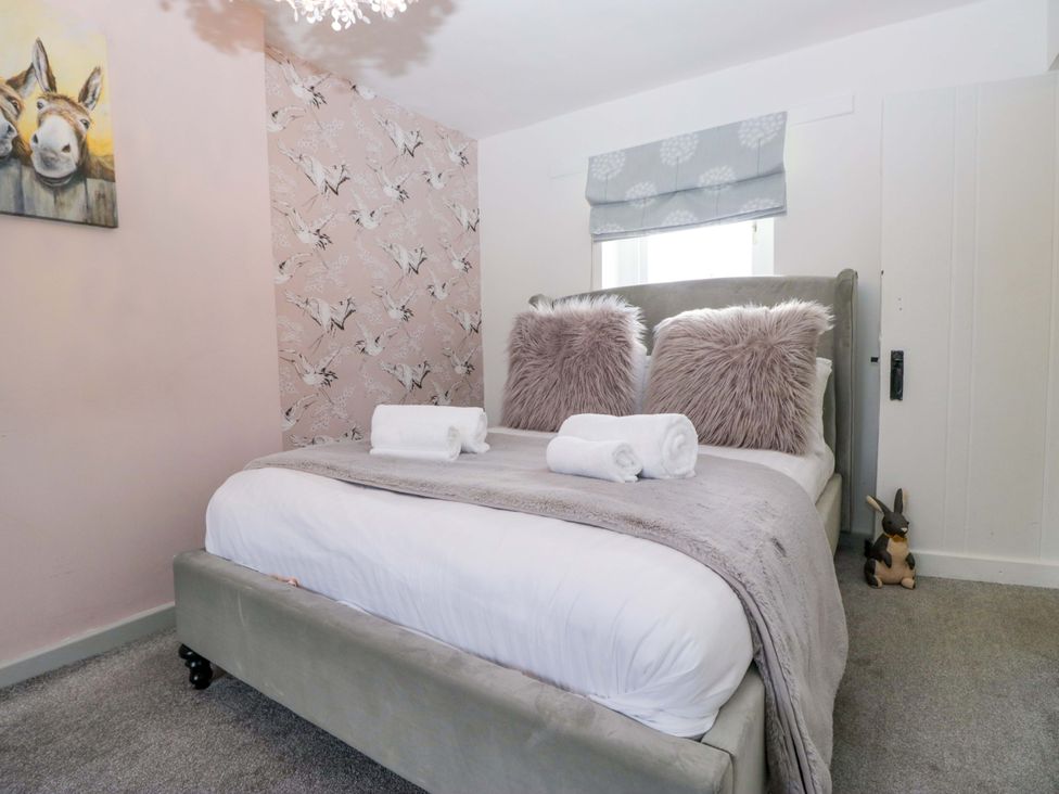 A bedroom with a bed and wall art at The Old Post Office in Whitehaven