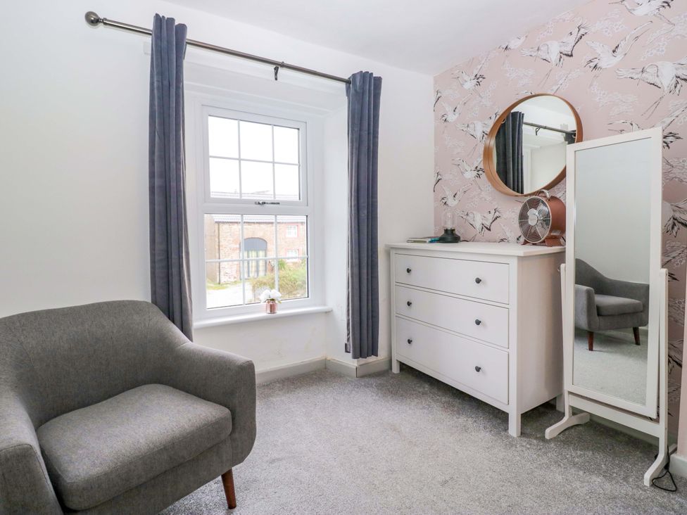 A bedroom with a window and a dresser at The Old Post Office in Whitehaven