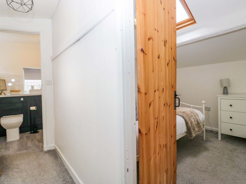 A bathroom and bedroom area with a toilet and bed at The Old Post Office in Whitehaven