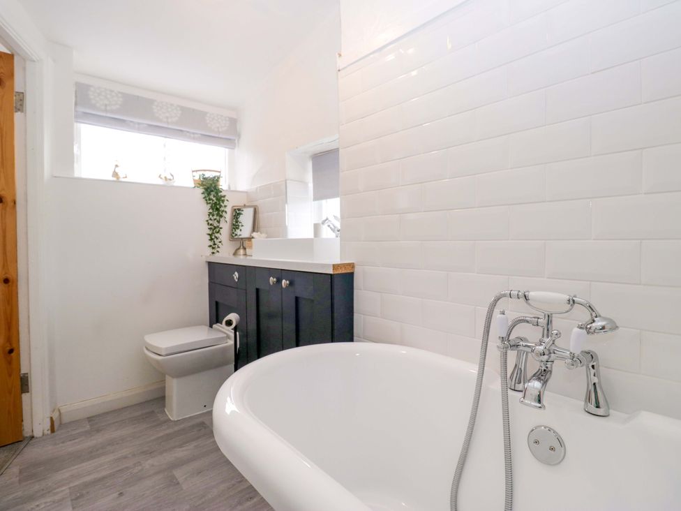 A bathroom with a bathtub, toilet, and sink at The Old Post Office in Whitehaven