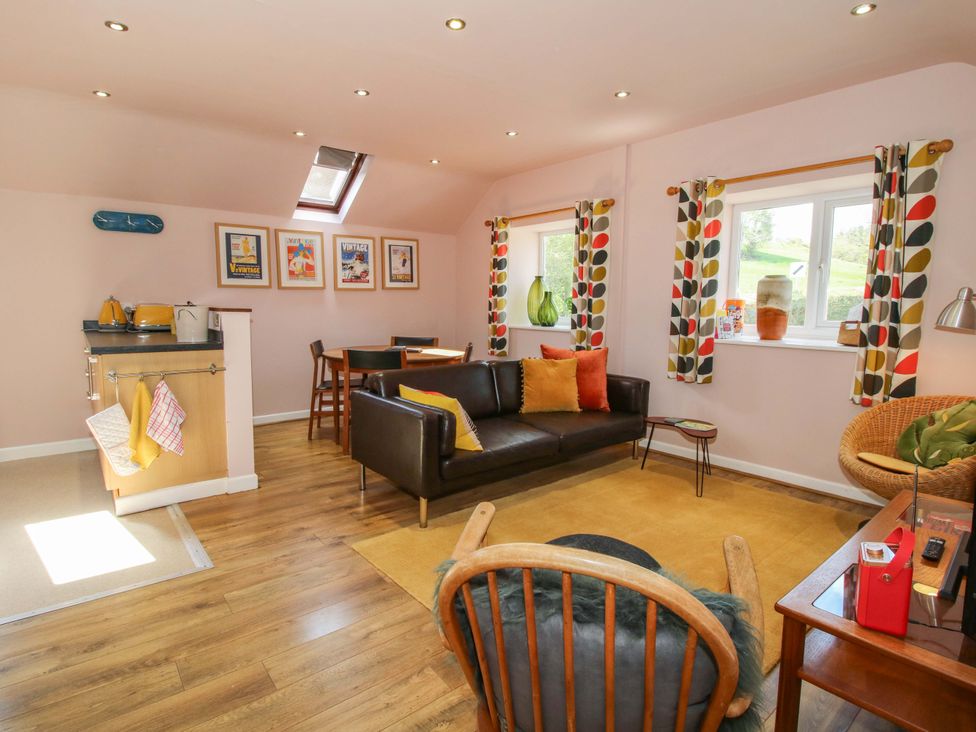 A living room with a couch and dining table at Pentwyn Barn Clyro