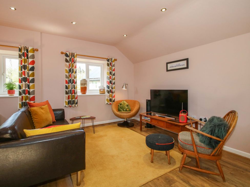 A living room with a television and seating area at Pentwyn Barn in Clyro