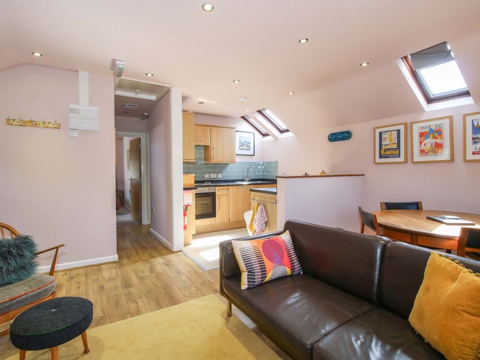 A living room with a sofa and dining table at Pentwyn Barn in Clyro