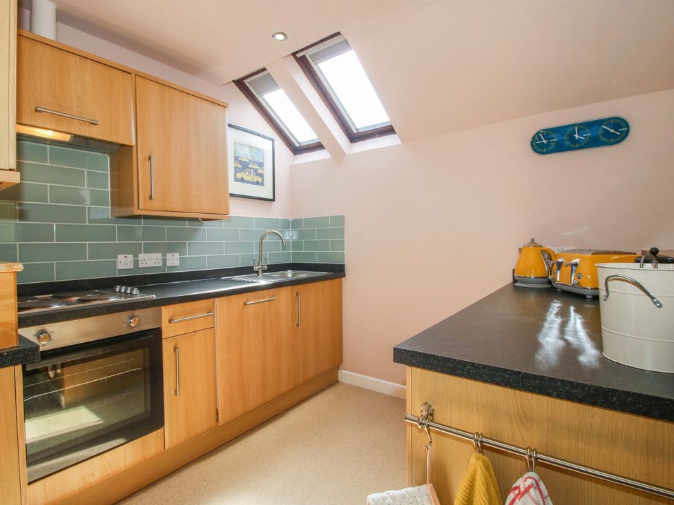 A kitchen with wooden cabinetry and modern appliances at Pentwyn Barn in Clyro