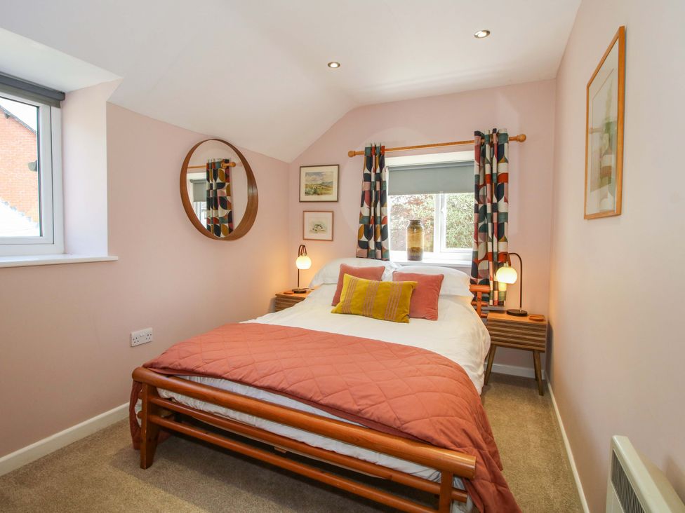 A bedroom with a bed and side tables at Pentwyn Barn in Clyro