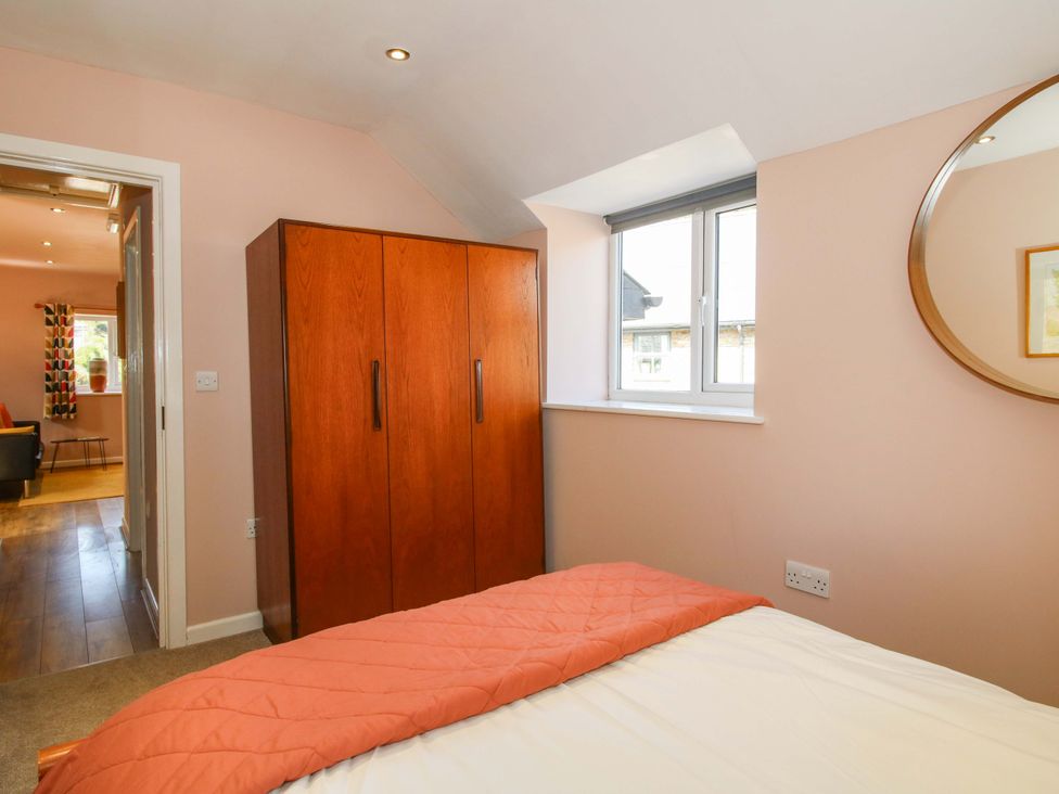 A bedroom featuring a wardrobe and a bed at Pentwyn Barn Clyro